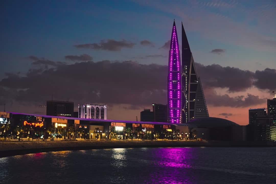 Photo by Afsal Shaji a very tall building with a purple light on it's side