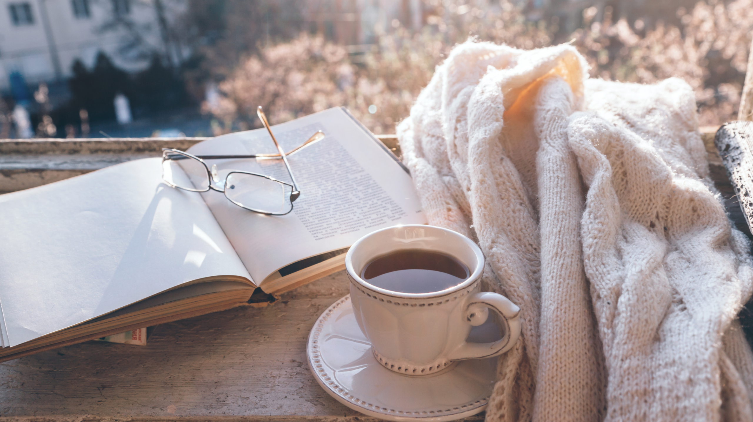 A cozy image of an open book, reading glasses and a cup of tea as a featured image for literary associate Ivanka Dimitrova