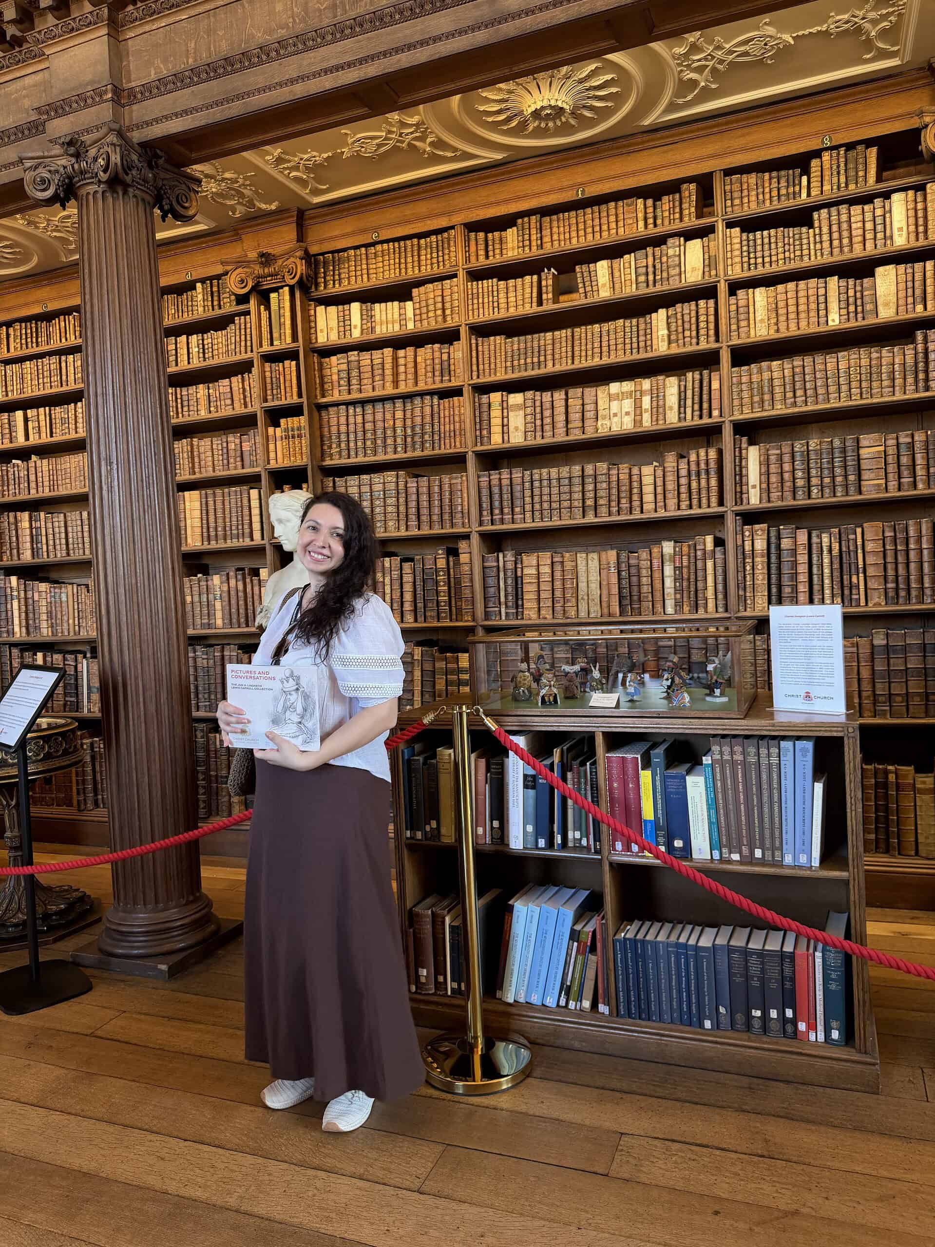 Writer, literary associate, and founder of Whispers at the Garden Gate LLC, a literary travel and lifestyle boutique brand standing at the Christ Church Library in front of the office of Charles Lutwidge Dodgson, known as Lewis Carrol, during her Oxford residency.